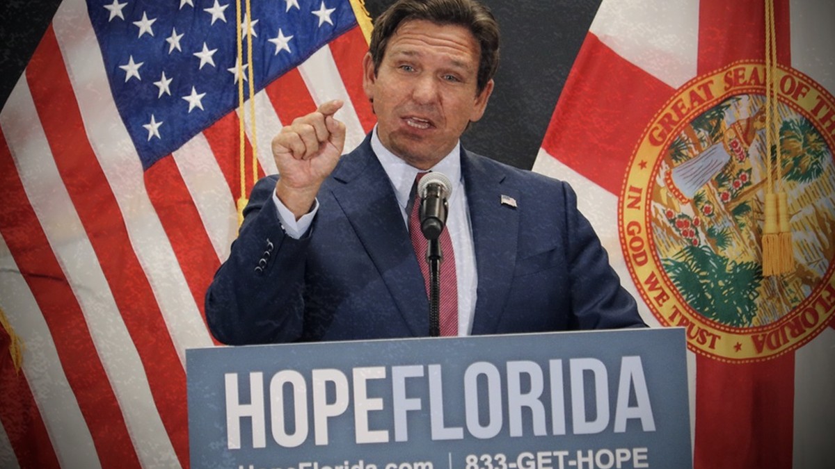 Ron DeSantis speaking at a Hope Florida podium